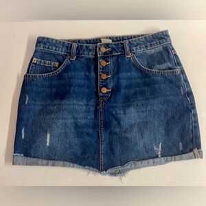 Roxy-denim mini skirt with raw hem and manufactured distressing.Size 12